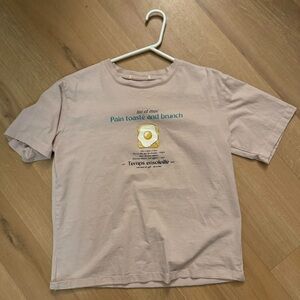 Pink women’s graphic tee with French breakfast design